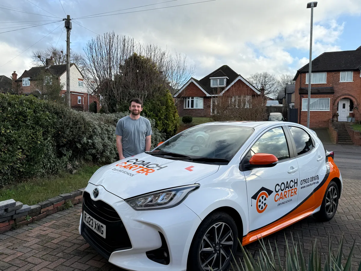 Fraser from CoachCarter beside the dual-controlled driving school car